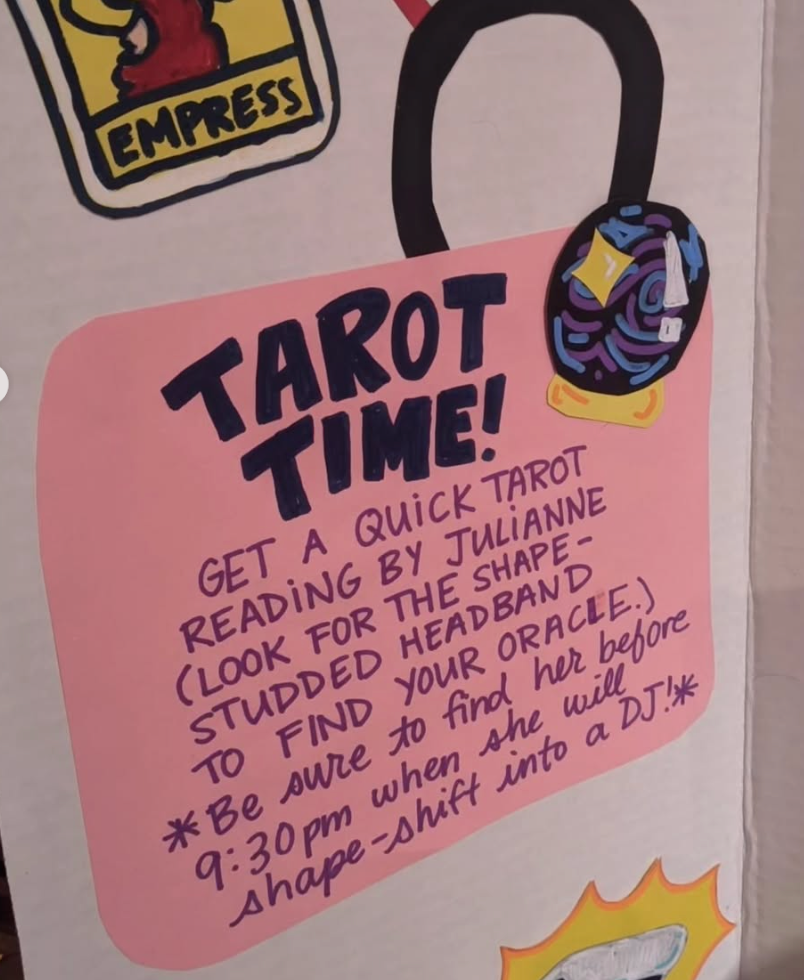 Promotional sign for a tarot reading event with text and graphics on a pink background. Text reads: Tarot Time! Get a quick tarot reading by Julianne (look for the shape-studded headband to find your oracle). * Be sure to find her before 9:30pm when she will shape-shift into a DJ! *